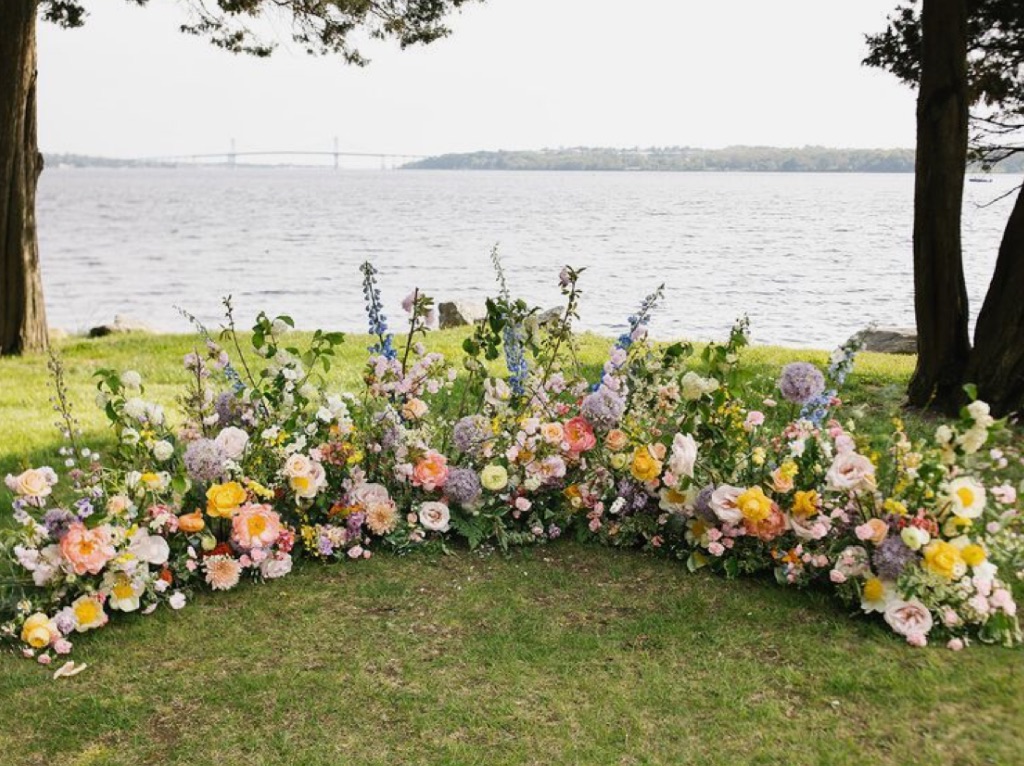Colorful pastel ground garden by water. Spring flowers. 